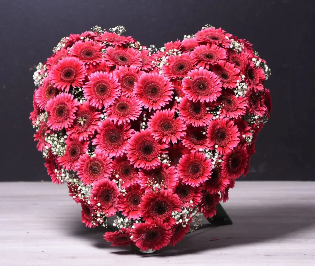 Blumenherz mit roten und hellen Blüten als persönlicher Abschiedsgruß