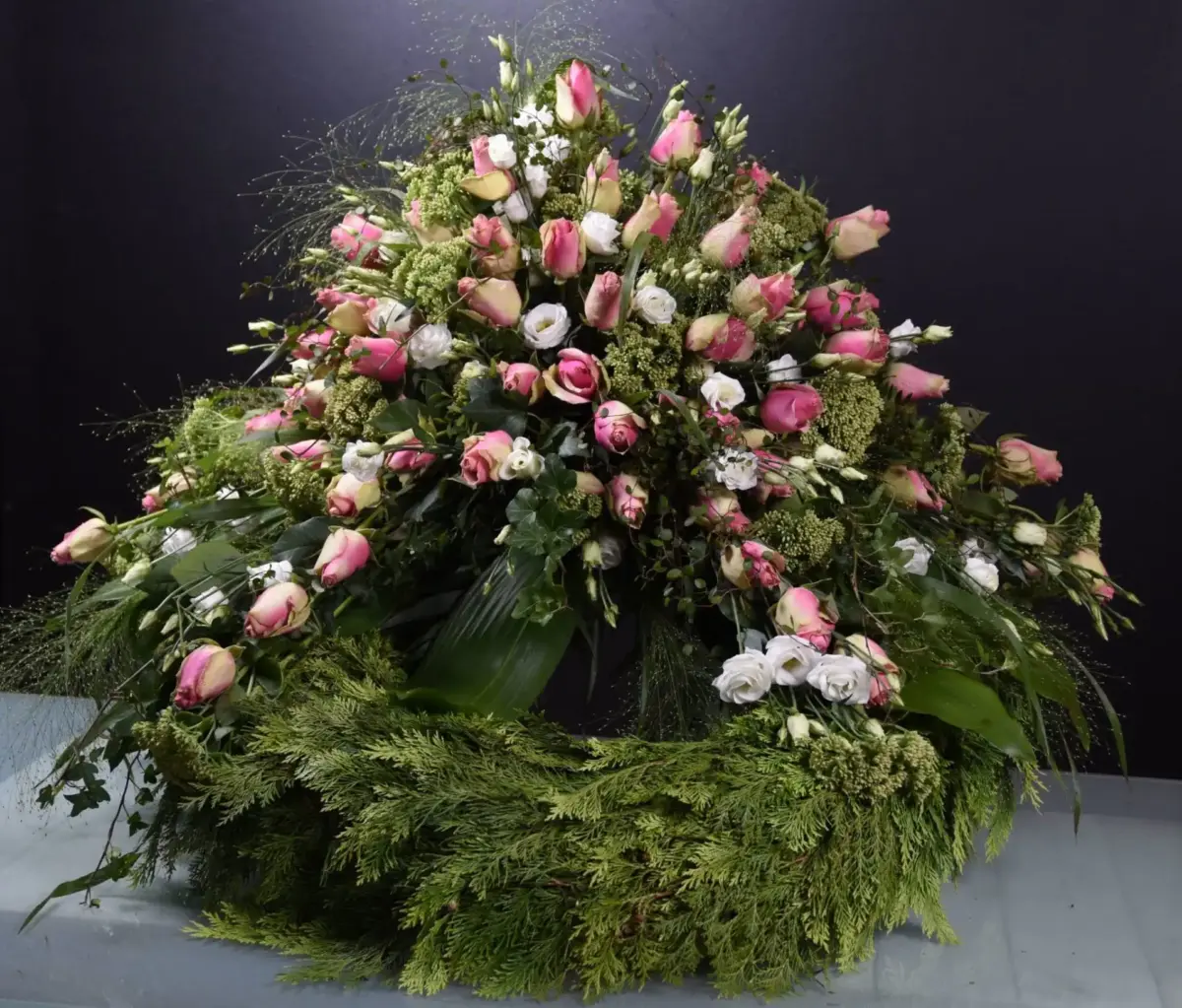 Trauerkranz mit hellen Blüten und grüner Ausarbeitung für eine Beisetzung